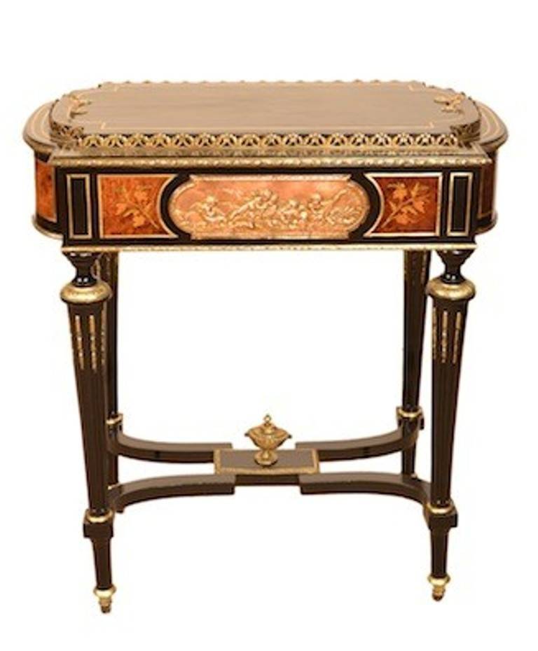 This is an antique ebonized and ormolu mounted jardiniere table, circa 1880.

The jardiniere is of rectangular form and has embossed plaques of cherubs on each side. There are beautiful burr walnut panels with exquisite floral marquetry on each