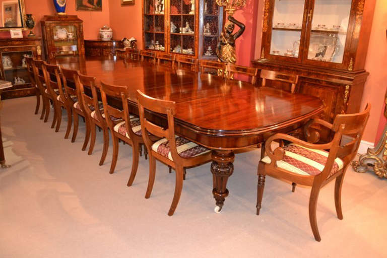 This is a rare opportunity to own an English antique Victorian flame mahogany dining or conference table, circa 1860 in date, with a beautiful vintage set of sixteen chairs. 

The table is very versatile and has five original leaves which can be