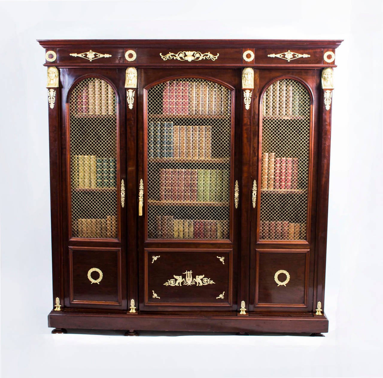 This is a beautiful antique French Empire mahogany bookcase with fabulous ormolu mounts circa 1840 in date. 

It has been crafted from solid mahogany and is smothered in fabulous ormolu mounts reminiscent of the Empire style with Egyptian motifs