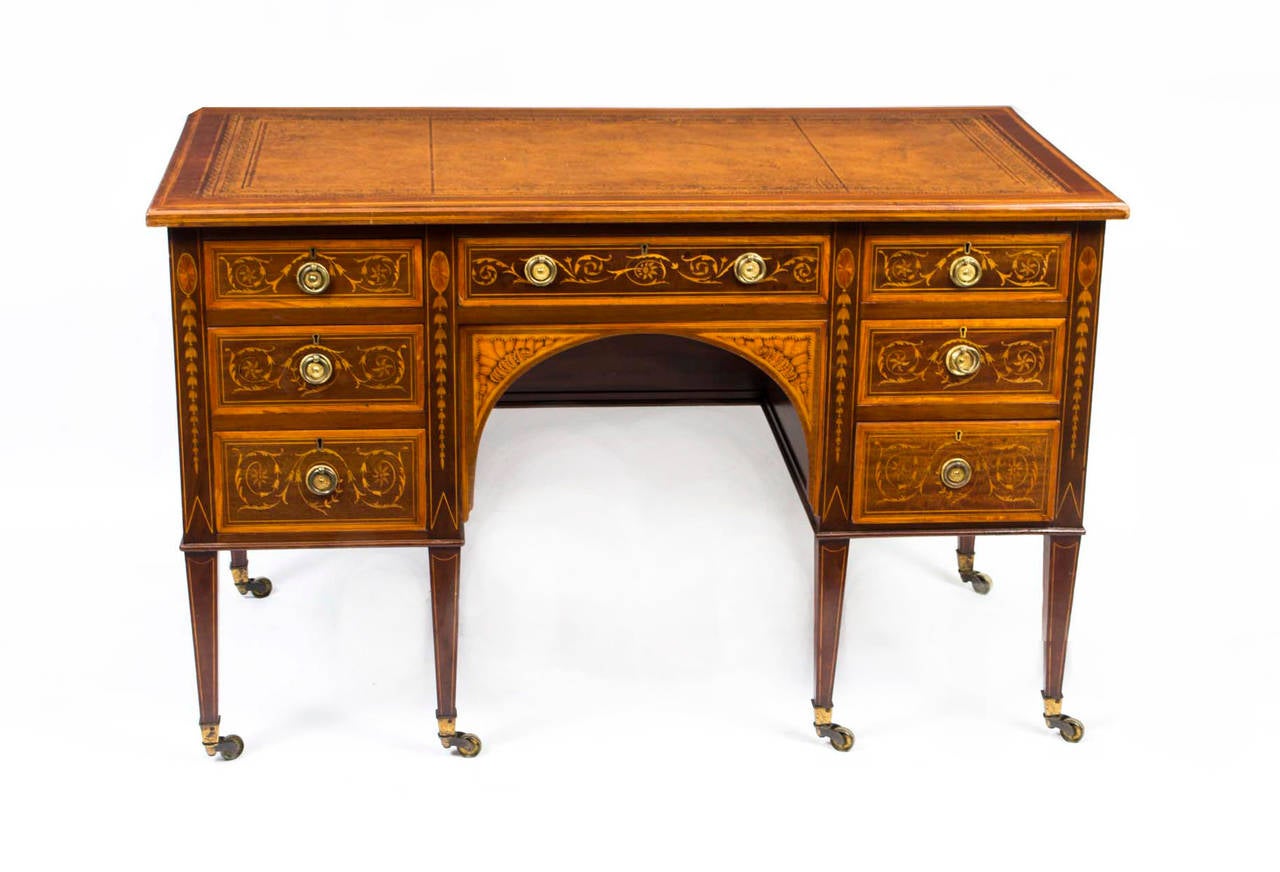 This is a stunning antique Edwardian pedestal desk, circa 1890 in date. 

It has a tan leather writing surface with hand tooled gold leaf decoration. It is made of solid mahogany and crossbanded with boxwood and ebony line inlay. It has seven