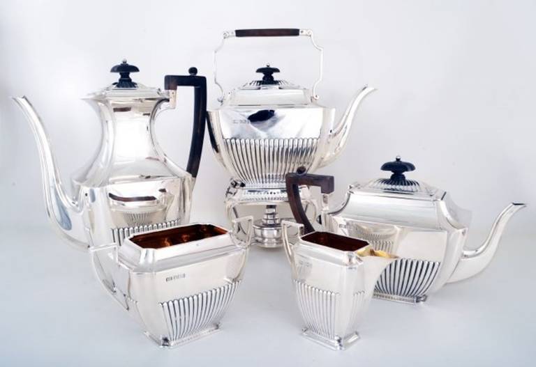 This is an exquisite five piece antique sterling silver set with hallmarks for Sheffield 1898 and the makers mark of the renowned silversmiths Henry Atkin. 

The set comprises a kettle on stand with burner, a coffee pot, a tea pot, a cream jug and