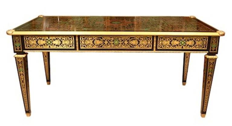 This is an absolutely stunning, antique, French 'boulle', cut brass and ebonized library table with fabulous ormolu mounts, circa 1900 in date. 

The desk is beautifully inlaid in cut brass with an intricate floral marquetry of cut brass. The are