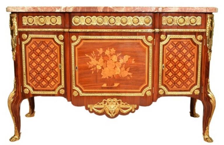 This stunning Antique French commode is in the French Louis XV/XVI transitional style and dates from the early 20th Century. 

It was crafted from the most beautiful kingwood, has the most wonderful ormolu mounts with exquisite floral marquetry