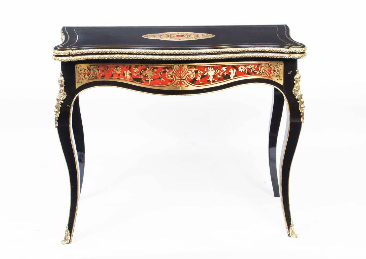 This is a lovely, antique, French inlaid 'Boulle' and tortoiseshell, ebonised card table with fabulous ormolu mounts, circa 1860 in date. 

The table has a beautifully inlaid centre which depicts a putti with pigeons. The sides of the table are