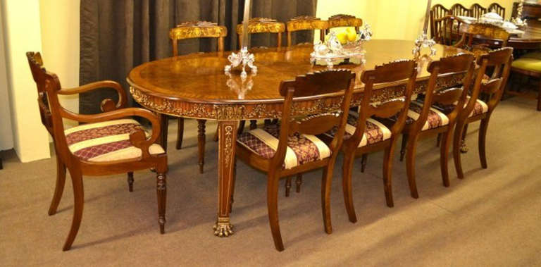 This is a very impressive and rare extending dining table in the Neo Classical style, Circa 1920 in date, with a matching set of ten burr walnut and inlaid chairs. 

The table is made of burr walnut and mahogany and is decorated with a profusion