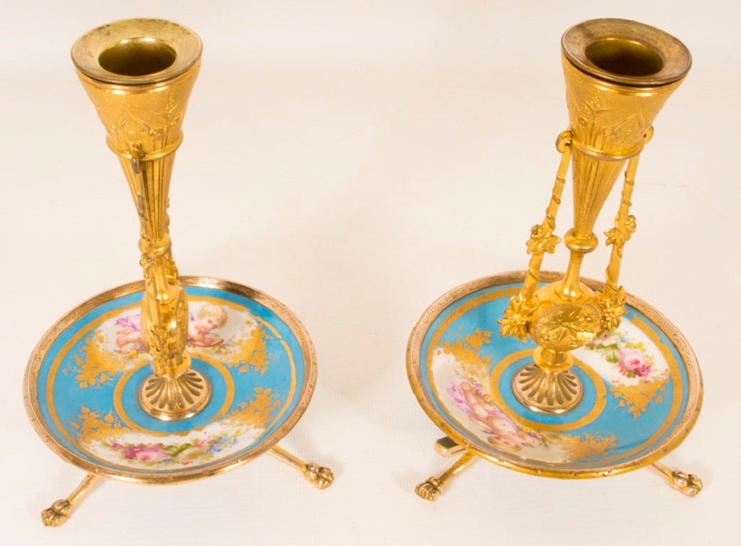 This is a fabulous antique pair of ormolu and hand-painted bleu celeste Sevres porcelain candlesticks, circa 1880 in date. 

The candlesticks feature porcelain saucers bases each decorated with a cherub and floral sprays with gilded decoration.