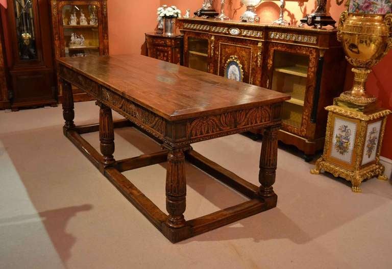 There is no mistaking the style and design of this exquisite antique English solid oak refectory table, in the Jacobean style, Circa 1880 in date and the set of eight vintage English solid oak Spindle Back dining chairs, comprising six chairs and