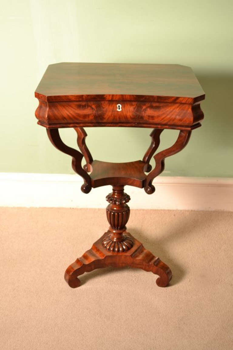 This is an elegant antique Victorian flame mahogany work table with quarter-veneered top, c.1880 in date. 

The rising lid reveals numerous compartments which originally would have been used for holding your sewing necessities, today it is for