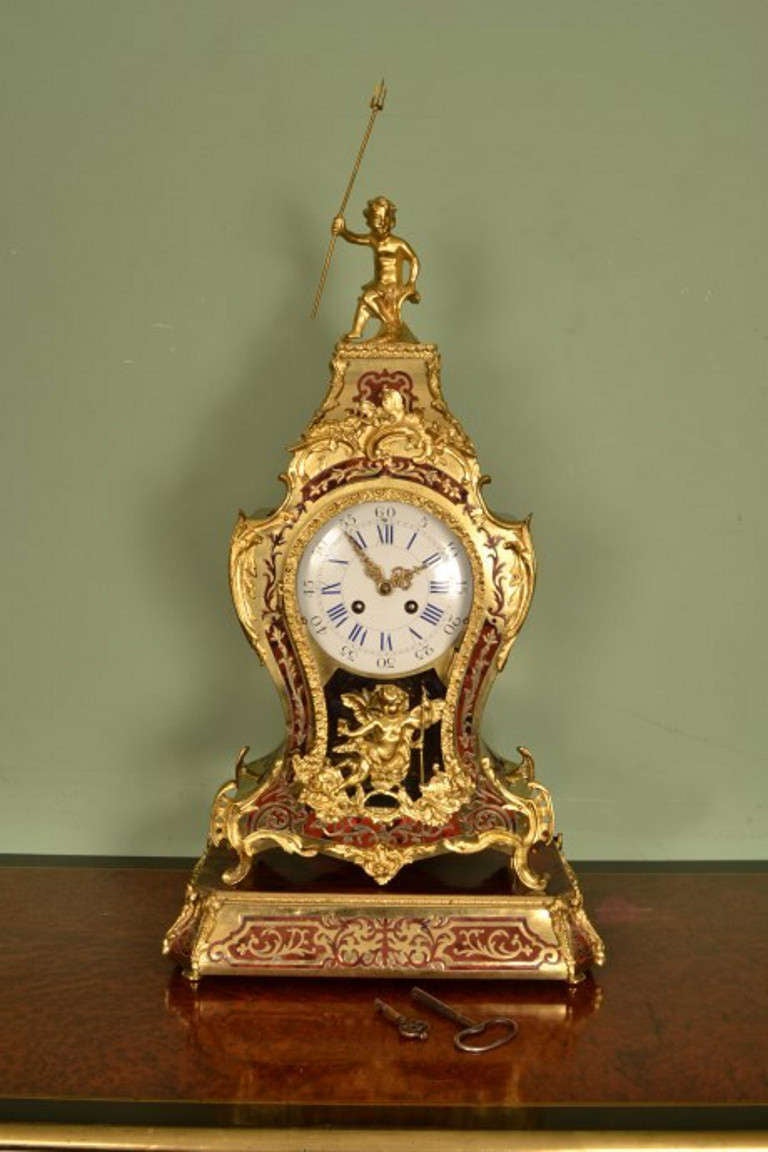 This is a beautiful antique French inlaid 'Boulle' and ormolu mantel clock on stand, circa 1860 in date.

This clock has a fabulous brass and enamel dial and a bell striking movement with a stamped mark for J Marti. There is also a stamp of the