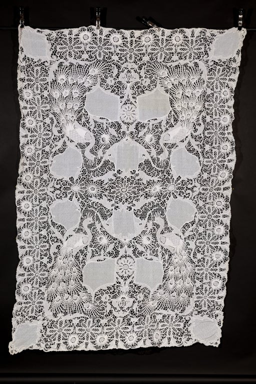 White linen cutwork tablecloth with floral and peacocks as the design