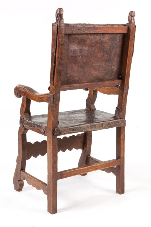 Carved wood with incised patterned leather on seat and back.