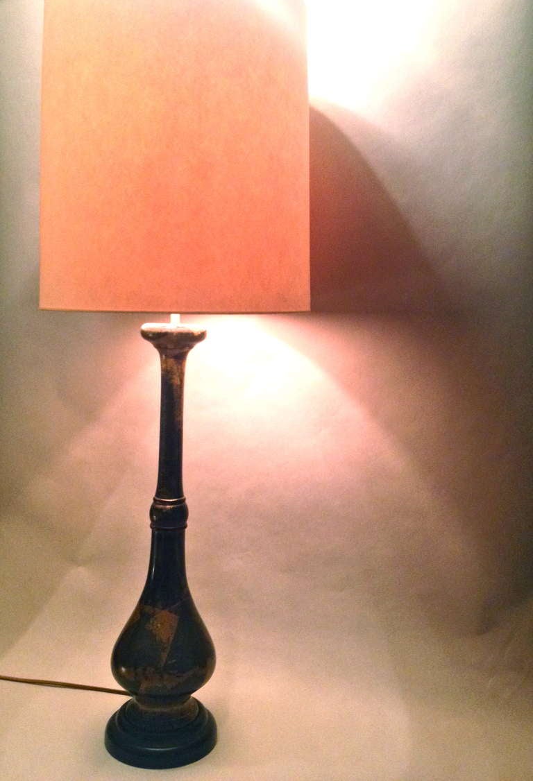 Tall, single table lamp, with classical Asian motif. Cast and turned bronze, with deep lacquered surface, and fire gilding. Mounted on lacquered wooden base.Lampshade pictured for dispay puposes only.