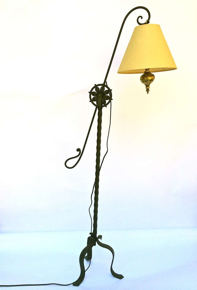 Arts and crafts period floor lamp, with bent iron tripod footing, and pivoting armature. Restrained and whimsical design, merging 19th century design and construction with 20th century dynamics. Brass counterbalance, with bulb and shade balanced