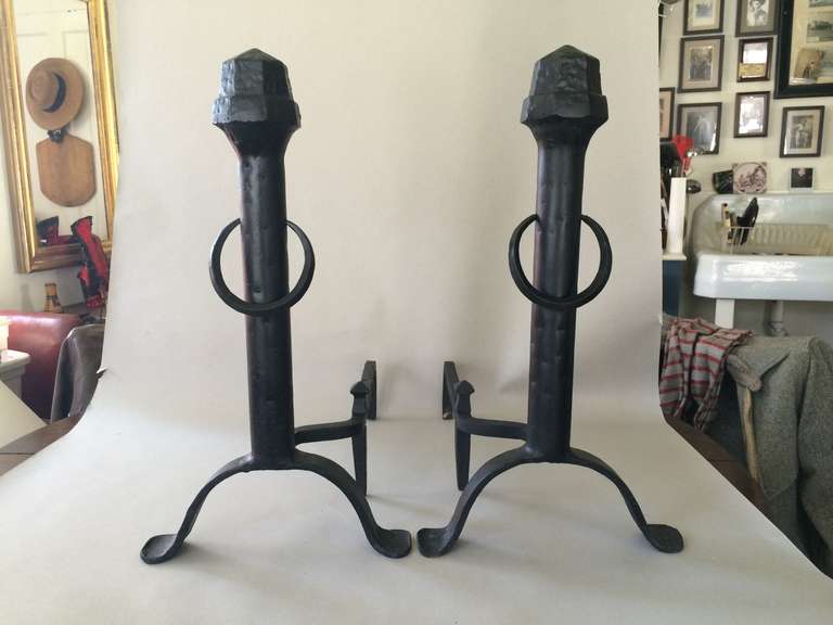 A matched pair of Hand wrought and cast iron andirons. Strong vertical stem with hand hammered tops and splayed wrought iron legs,