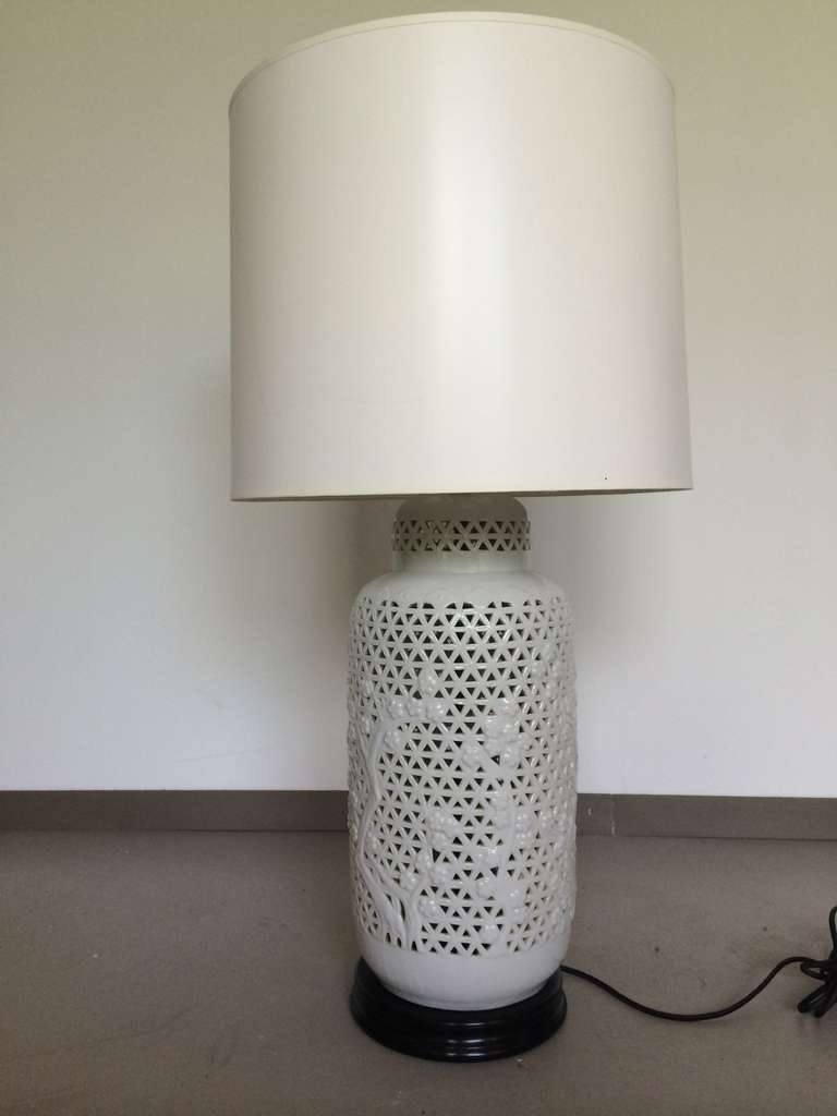 Large molded porcelain table lamp with open fretwork pattern and figural blossoming tree motif. Wooden lacquered base and original finial. Restored and rewired. Shade is for display purposes only.
