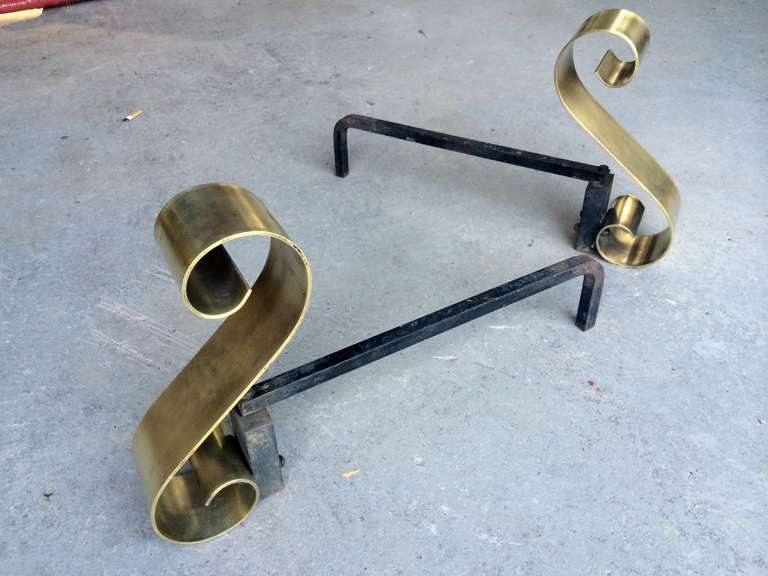 A matched pair of machined bronze and iron andirons. Strong, simple design with full 45 degree angle arcing over iron chenets. Solid, heavy gauge bronze adds weight to presence.