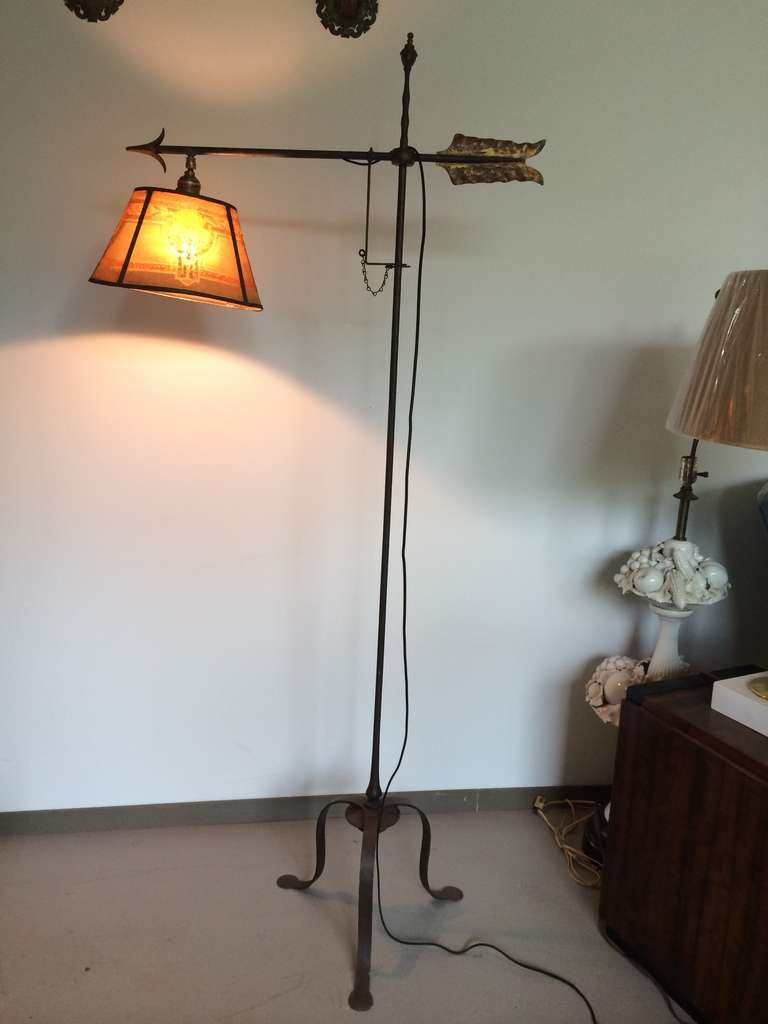 Large scale wrought iron floor lamp from the American Arts and Crafts period. Retains its original bronze finial and counterweight at base. Tin or iron feather has gilded surface. Includes printed screen shade, from the period. A beautiful, full