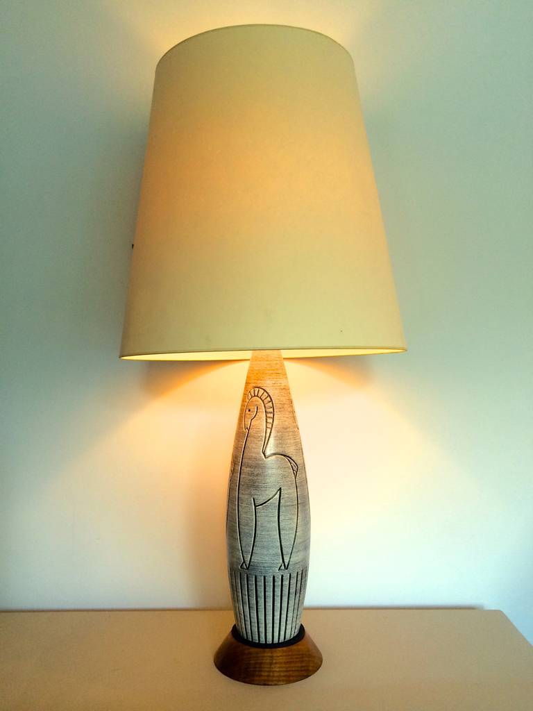 A single Italian pottery table lamp with repeating horse motif. Horizontal wash of grey with incised line drawings. Mounted on a solid walnut base, with matte black metal disc and new electrical hardware. Shade pictured is for display purposes only.