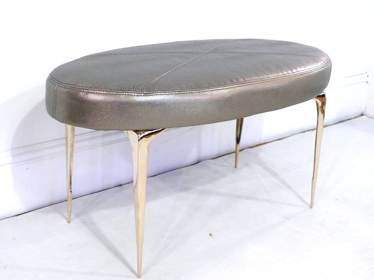 Elegant pair of oval signature Stiletto ottomans designed by Irwin Feld Design for CF Modern.
These ottomans feature four of our hand cast and hand polished brass sculptural 