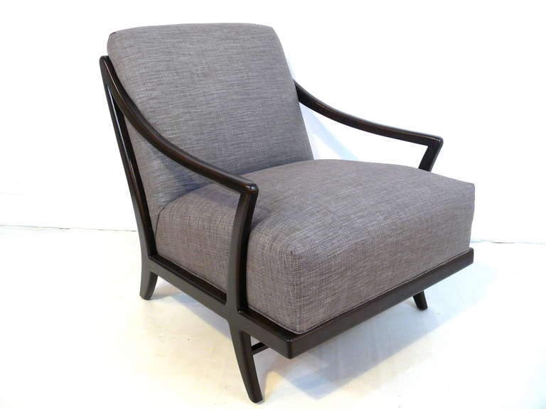 The saber chair by Irwin Feld Design for CF Modern features a solid wood frame as well as tight back and seat upholstery. Inspired by the great Mid-Century modern masters, the chair features sculpted lines and an exposed frame. Shown in dark