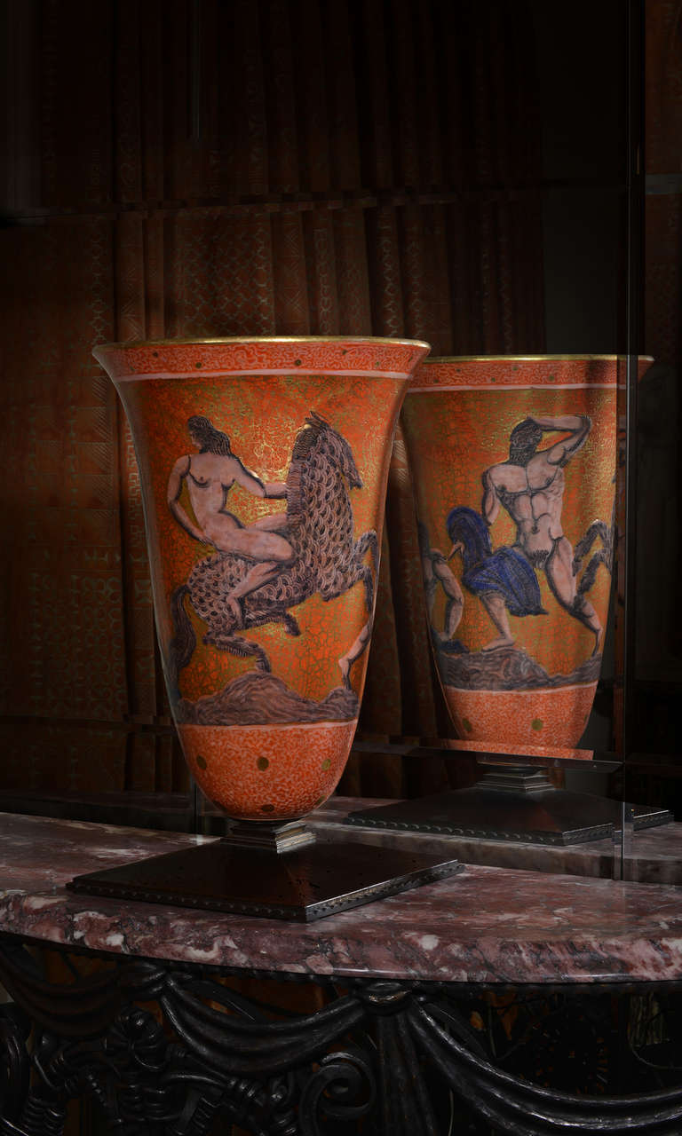 This magnificent ceramic urn is arguably the greatest work of Mayodon, exhibiting great artistry both as a ceramist and as a painter. It is decorated with a mythological theme with nude males and a rider on a horse on a rich orange and gold ground.