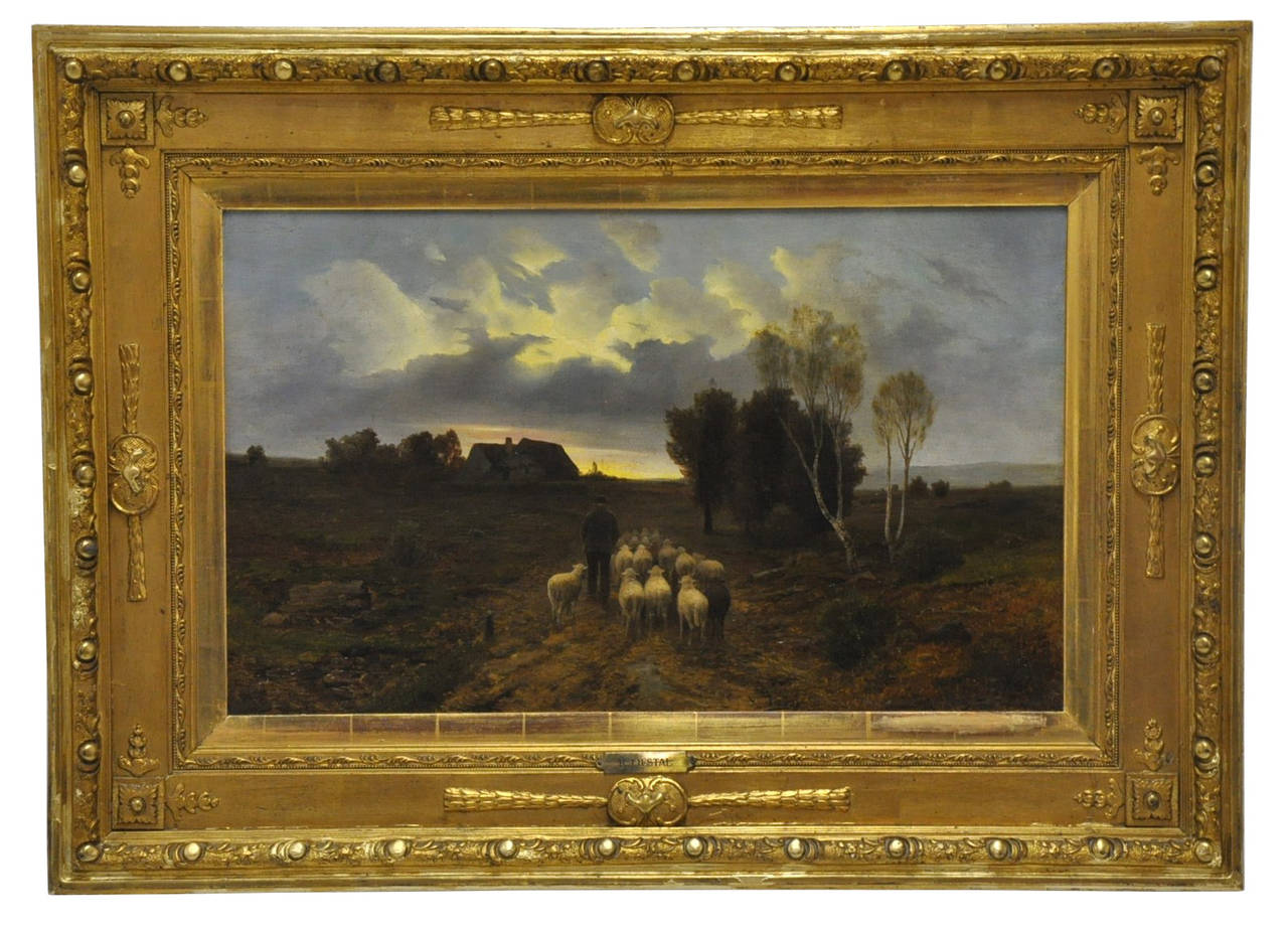 Early 19th century French oil on canvas in an exquisite gold leaf frame, featuring a shepherd and his flock of sheep returning to the pen at the end of the day.  Beautiful sky with sunset behind the clouds. The frame and canvas are signed 