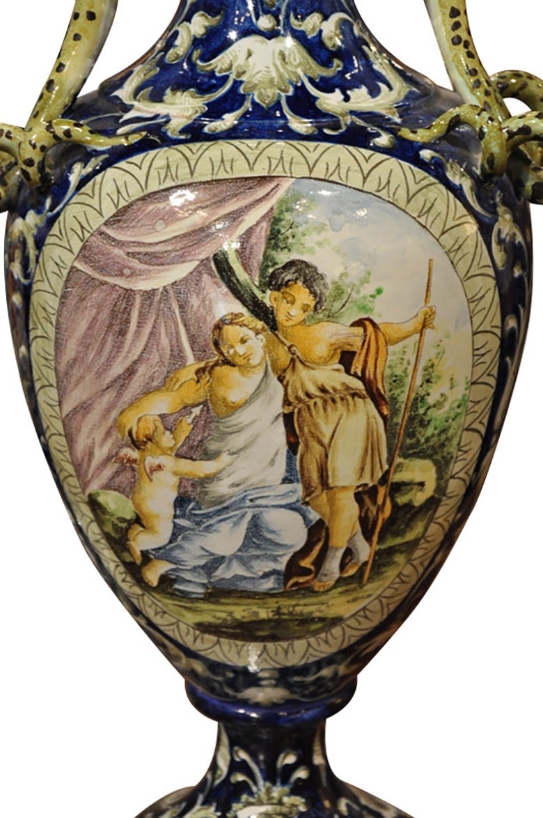 Pair of 19th century painted Italian Majolica vases, supporting with curved handles, circa 1890. Both vases have mythological scenes painted on the front.