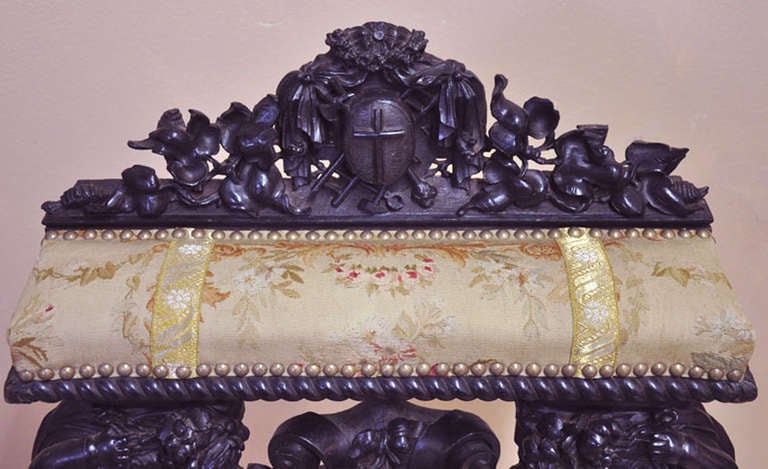 French 19th C Ebonized Prie Dieu with beautiful carving, Aubusson tapestry panels lined with vintage gold thread trim. Legs of the cherubs have been replaced along with repair to lower portion of central emblem.