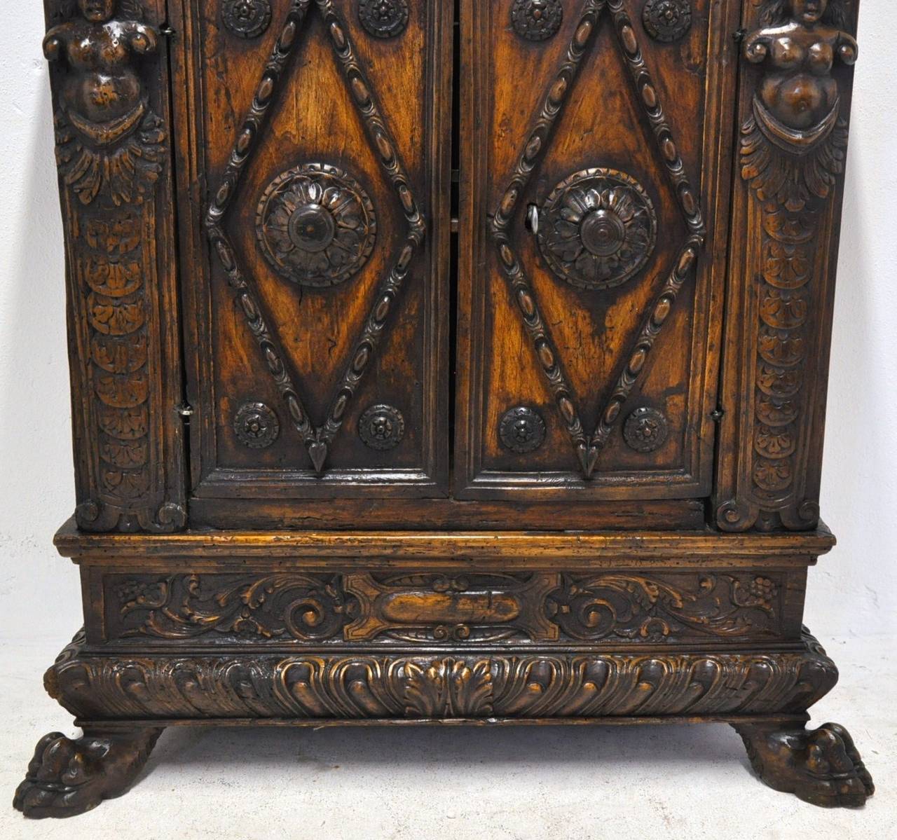 18th century walnut baroque Italian hall cabinet (c:1760), featuring a scalloped frieze with a pair of drawers above doors flanked by female busts and supported by paw feet. Beautiful patina.