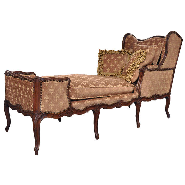 Nicely carved antique walnut chaise lounge from Lyon, France, circa 1780. Completely redone with new Fleur-de-lys fabric. Includes two pillows with matching trim.