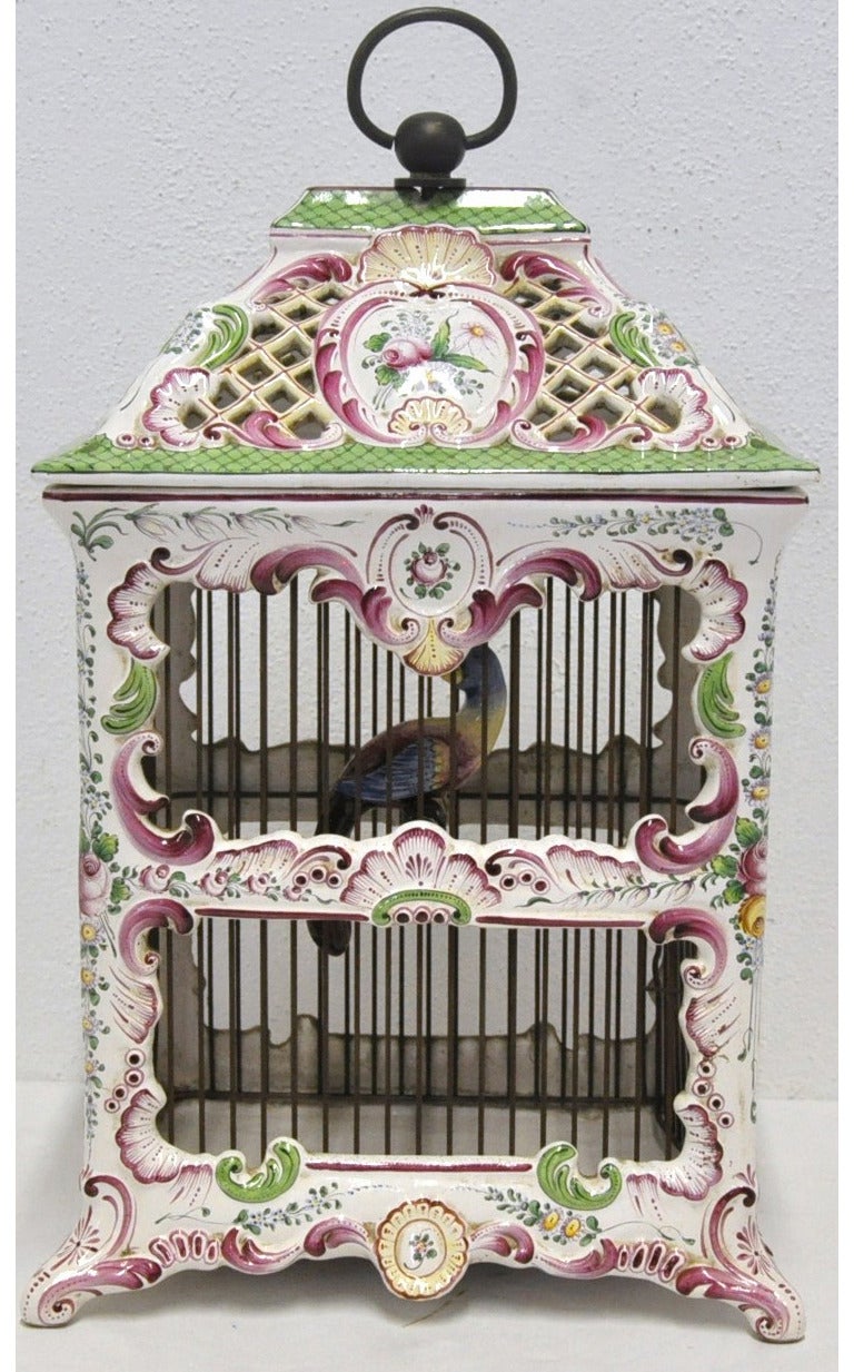 This beautiful, feminine porcelain birdcage would make a lovely addition to a woman's office or study. The hand-painted antique was crafted in 1880 and features a porcelain bird sitting on a brand inside a ornate cage. The original French wiring