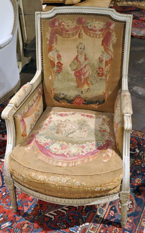 Charming pair of antique bergeres armchairs with original Aubusson tapestry from the Provence region of France, circa 1860. Each tapestry, featuring a young girl carrying fruits and a young fisherman on each back with sheep, goat, monkey and frog on
