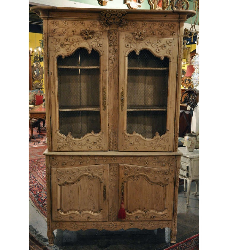 This beautiful, antique buffet-deux-corps was crafted in Rouen, France circa 1780. This carved buffet has been stripped and bleached to reveal a soft, natural  wood finish. The buffet features a carved flower basket at the top with garlands, a pair