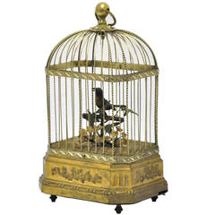 Vieux oiseau mécanique européen chantant dans une cage en laiton
