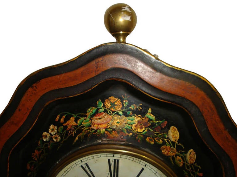 Decorate your breakfast room or kitchen with this antique Napoleon III wall clock from Paris, France, circa 1860. The oval tole time keeping features hand-painted flowers over a black background. The clock face is in good working order with pendulum