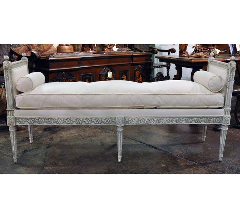 French 19th C. Louis XVI style Painted Banquette/Daybed. The bench features a new down-filled seat cushion and two bolsters, recovered in muslin and a distressed paint finish.