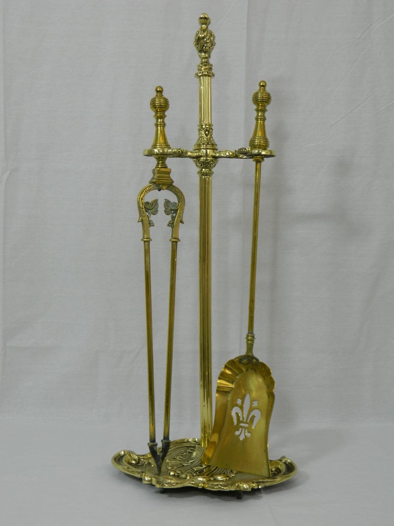 Set of French brass matched fire tools on stand. Set includes shovel, tongs and beautifully scrolled design stand. Base of stand is 11.5