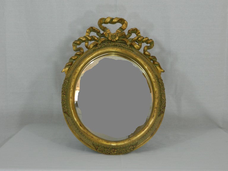 Miroir de courtoisie ovale en feuille d'or sculpté à la main en Italie au début du XXe siècle, avec un motif de ruban.
