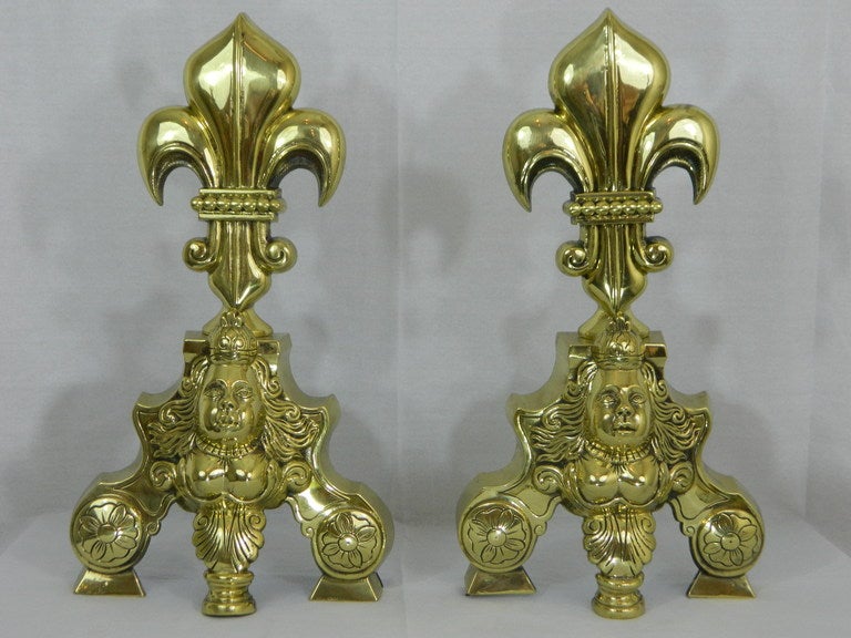19th century pair of chenets or andirons with large fleur de lis and cherubs motif.