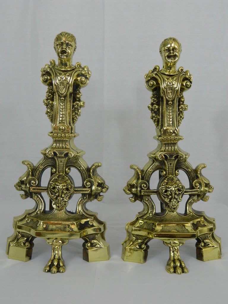 19th century pair of chenets or andirons with cherubs and lions motif ending on claw feet.