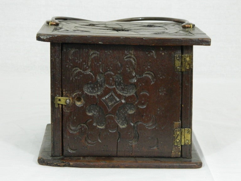 Continental carved oak foot warmer of rectangular outline with hinged front door, chip carved in a geometric foliate pattern, 18th century.
 