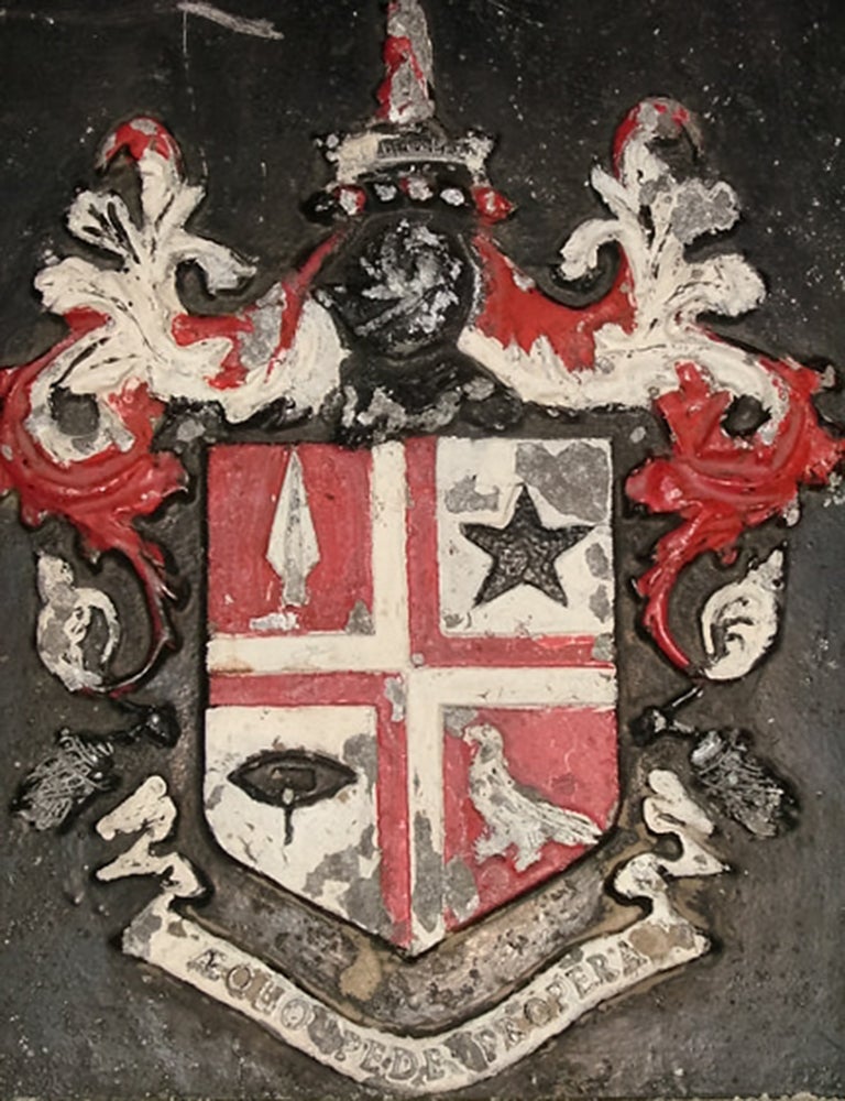 Late 18th-early 19th century coat of arms cast iron wall plaque with a black background and an inscription "Aequo Pede Propera".
  