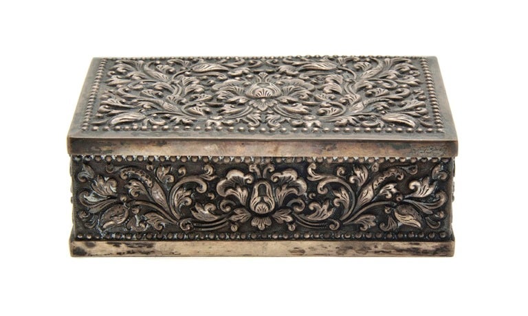 Early 19th century silver mounted cigarette box, of rectangular form with scrolling foliate decoration in relief, stamped 900.