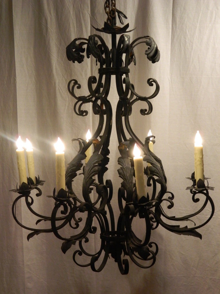 Mid-20th century French iron eight-light chandelier fitted with beeswax sleeves. Rewired.