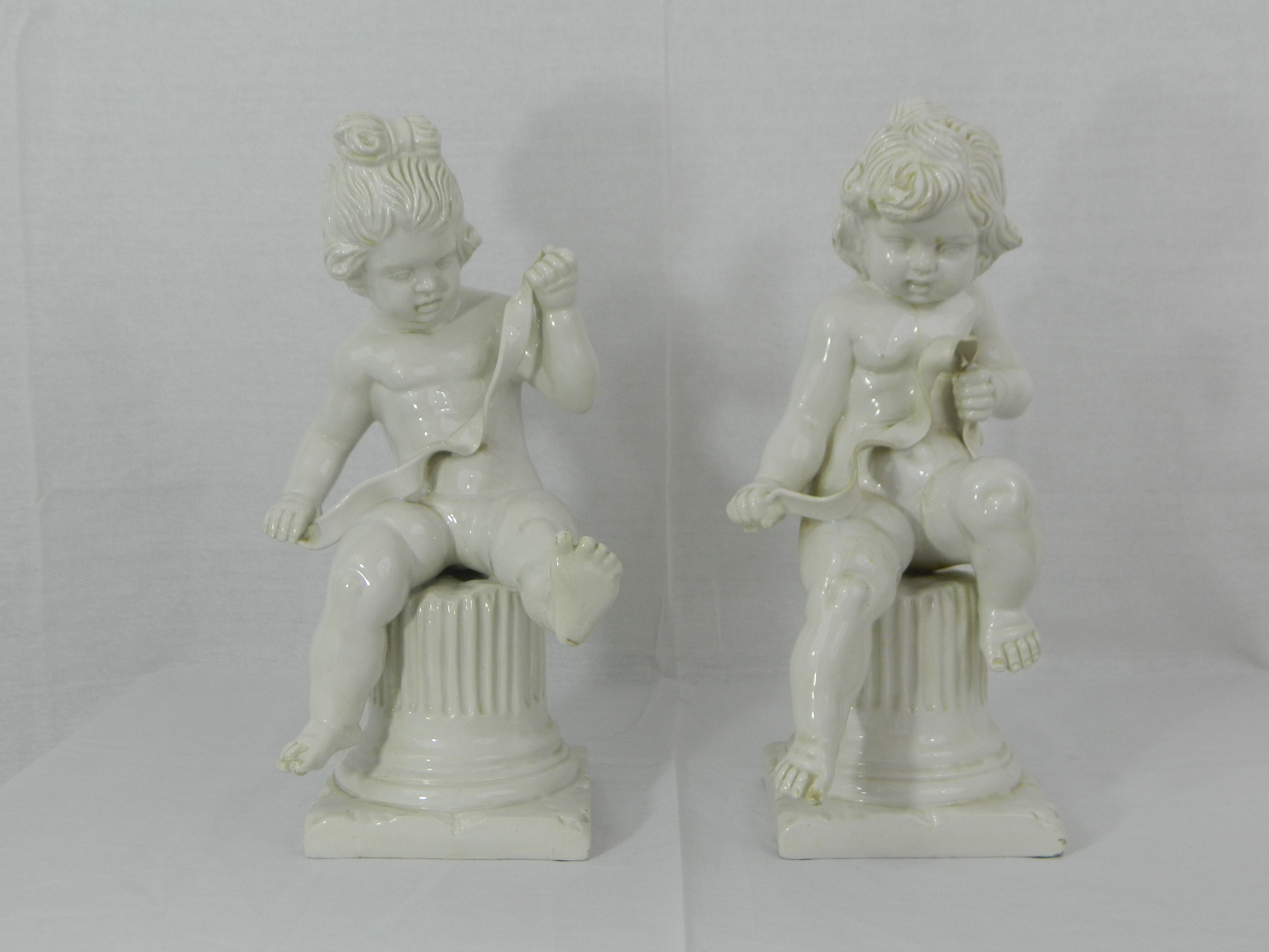 Pair of Italian White Bisque Cherubs Sitting on Column Pedestals