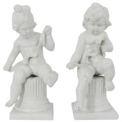 Pair of Italian White Bisque Cherubs Sitting on Column Pedestals