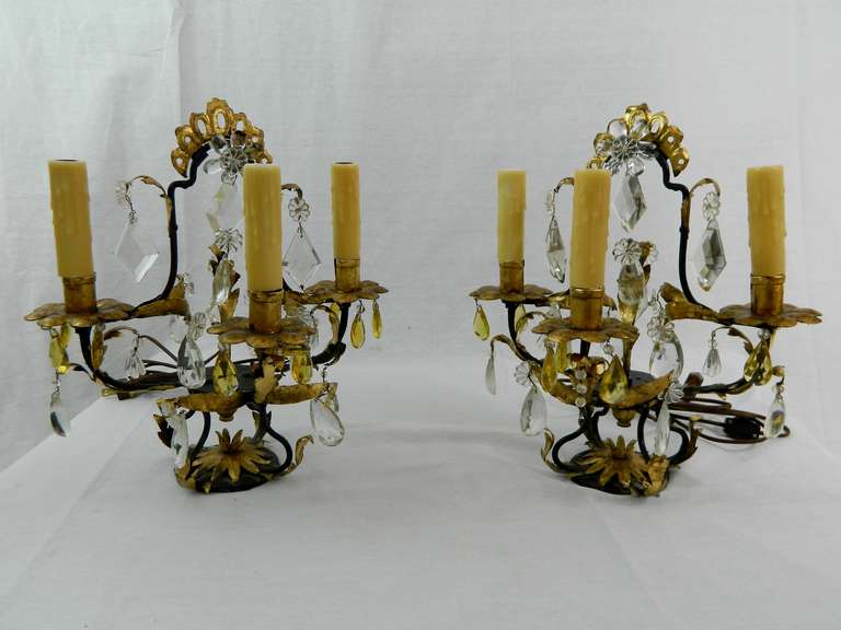 19th century pair of Italian Rococo style Tôle Peinte and cut-glass three-light Girandole or lamps, each with shaped standard issuing branches decorated with leaves and suspending pendants, electrified.