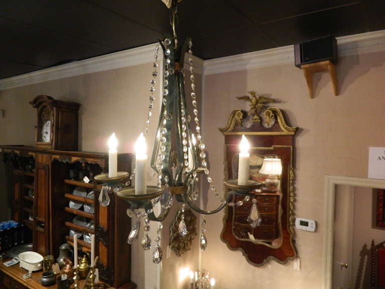 19th century French painted green and gold iron and crystal four-light chandelier fitted with bees wax sleeves.