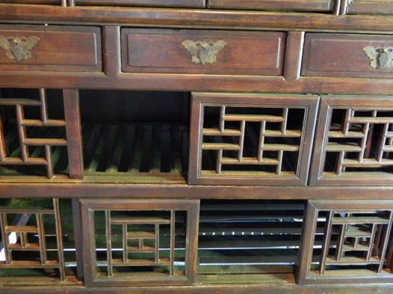 Early 20th Century Chinese Kitchen Cabinet Fitted with Two Bottom Shelves and Lattice Sliding Doors.  Three Center Drawers.   Two Shelves at Top with Four Panel Doors
