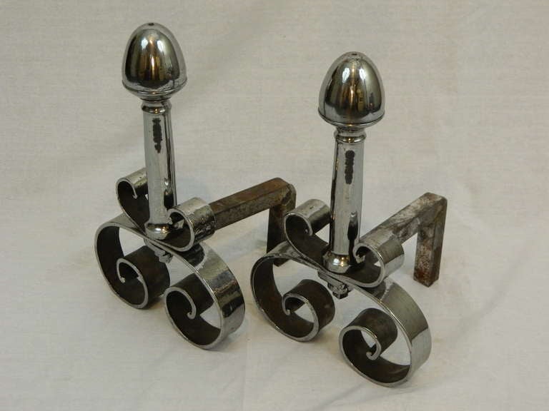 19th century pair of polished steel chenets or andirons with a scrolls motif.
